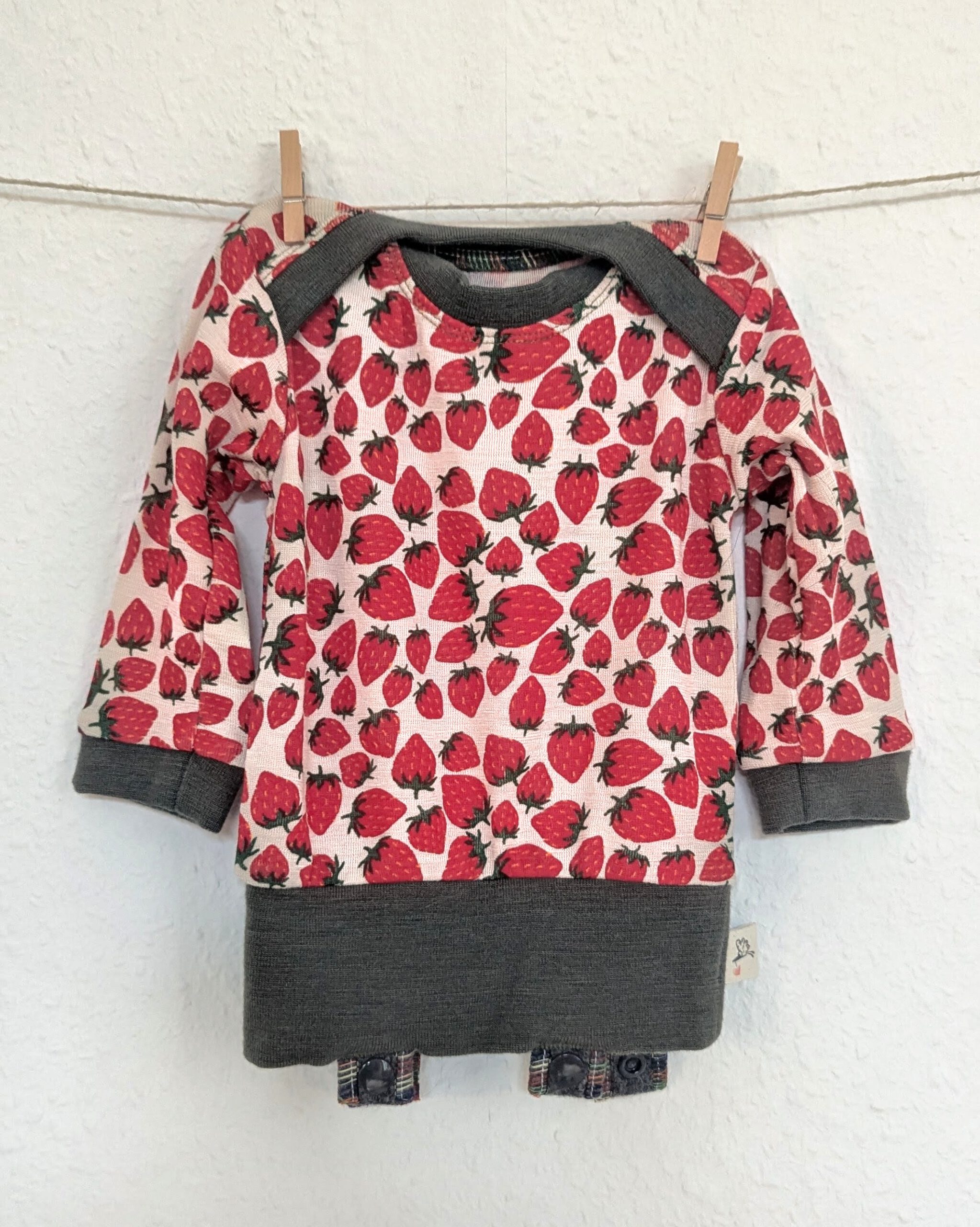 Abhaltebody Abraxas Gr. 68 Erdbeeren Langarm Shirt mit amerikanischem Ausschnitt, Erdbeermuster und farblich abgesetzten Bündchen an Ärmeln, Halsausschnitt und Bauch.
